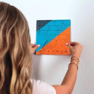 Orange and Blue on Brick Slidetile on wall in office.