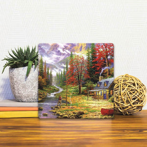 A Slidetile of the A Cabin on the River sitting on a table.