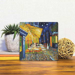 A Slidetile of the Café Terrace at Night by Van Gogh sitting on a table.