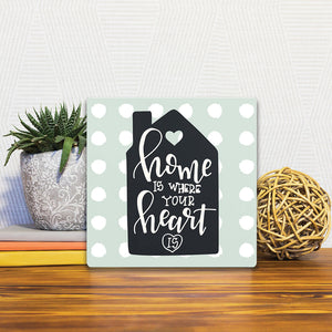 A Slidetile of the Home is where the heart is sitting on a table.