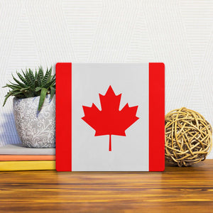 A Slidetile of the The Canada Flag sitting on a table.