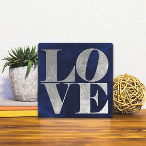 A Slidetile of the Love on Blue sitting on a table.