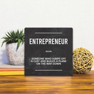 A Slidetile of the Definition of Entrepreneur sitting on a table.
