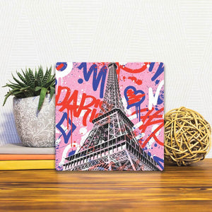A Slidetile of the Eiffel Tower Graffiti sitting on a table.
