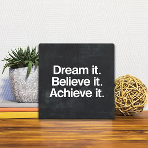A Slidetile of the Dream It. Believe it. sitting on a table.