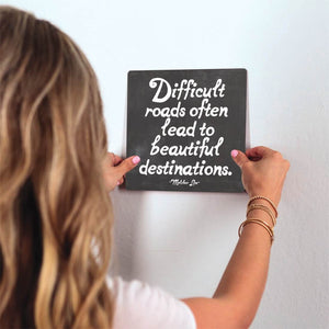 Difficult Roads Slidetile on wall in office.
