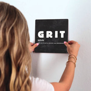 The Definition of Grit Slidetile on wall in office.