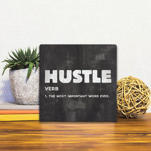 A Slidetile of the The Definition of Hustle sitting on a table.