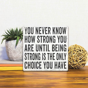 A Slidetile of the You Never Know How Strong You Are sitting on a table.