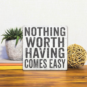 A Slidetile of the Nothing Comes Easy sitting on a table.