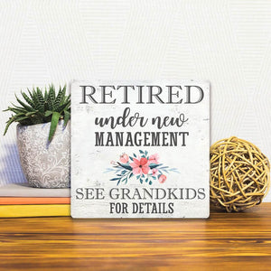 A Slidetile of the Under New Management sitting on a table.