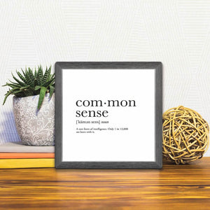 A Slidetile of the Definition of Common Sense sitting on a table.