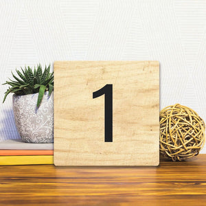 A Slidetile of the Number 1 - Light Wood sitting on a table.