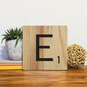 A Slidetile of the Letter E - Light Wood sitting on a table.