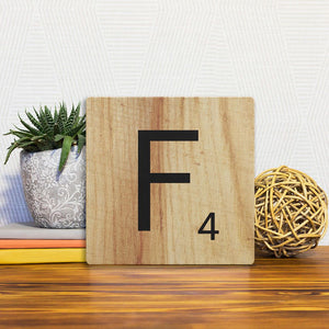 A Slidetile of the Letter F - Light Wood sitting on a table.