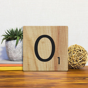 A Slidetile of the Letter O - Light Wood sitting on a table.