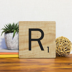 A Slidetile of the Letter R - Light Wood sitting on a table.