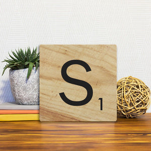 A Slidetile of the Letter S - Light Wood sitting on a table.
