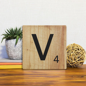 A Slidetile of the Letter V - Light Wood sitting on a table.
