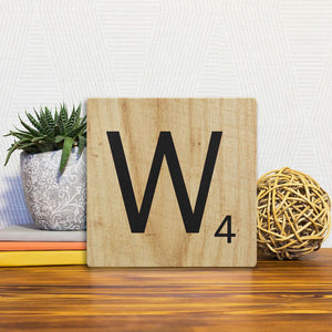 A Slidetile of the Letter W - Light Wood sitting on a table.