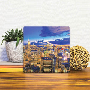 A Slidetile of the New York Skyline at Night sitting on a table.