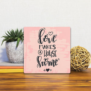 A Slidetile of the Love makes a house home sitting on a table.
