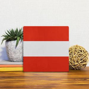 A Slidetile of the The Austrian Flag sitting on a table.