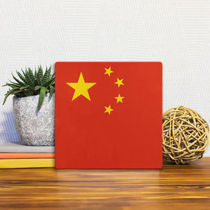 A Slidetile of the The Chinese Flag sitting on a table.