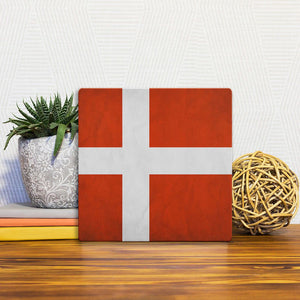 A Slidetile of the The Denmark Flag sitting on a table.