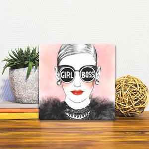 A Slidetile of the Girl Boss sitting on a table.
