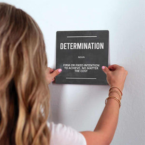 The Definition of Determination Slidetile on wall in office.