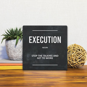 A Slidetile of the Definition of Execution sitting on a table.