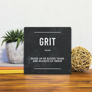 A Slidetile of the Definition of Grit sitting on a table.