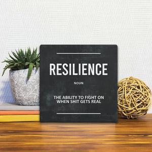 A Slidetile of the Definition of Resilience sitting on a table.
