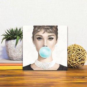 A Slidetile of the Hepburn Blows a Bubble sitting on a table.