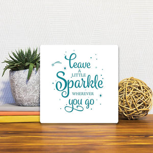 A Slidetile of the Leave a little sparkle sitting on a table.