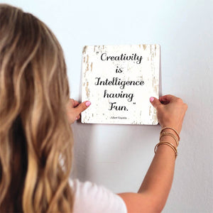Creativity is intelligence having fun Slidetile on wall in office.