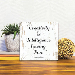 A Slidetile of the Creativity is intelligence having fun sitting on a table.