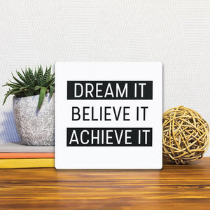 A Slidetile of the Dream it. Believe it… sitting on a table.