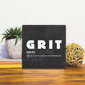 A Slidetile of the The Definition of Grit sitting on a table.