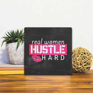 A Slidetile of the Real women hustle hard sitting on a table.