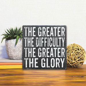 A Slidetile of the The Greater the Glory sitting on a table.