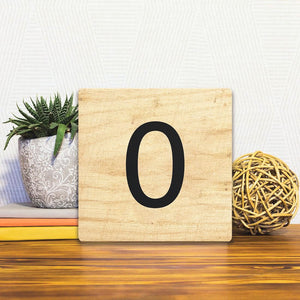 A Slidetile of the Number 0 - Light Wood sitting on a table.