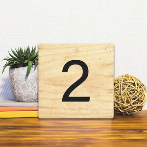 A Slidetile of the Number 2 - Light Wood sitting on a table.