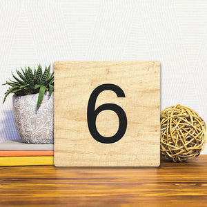 A Slidetile of the Number 6 - Light Wood sitting on a table.
