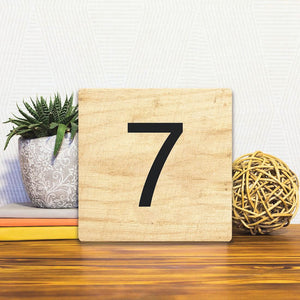 A Slidetile of the Number 7 - Light Wood sitting on a table.