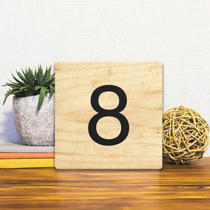 A Slidetile of the Number 8 - Light Wood sitting on a table.