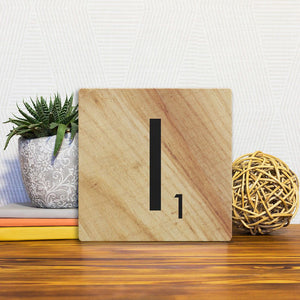 A Slidetile of the Letter I - Light Wood sitting on a table.