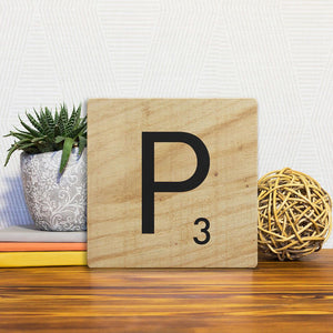 A Slidetile of the Letter P - Light Wood sitting on a table.