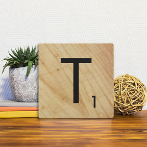 A Slidetile of the Letter T - Light Wood sitting on a table.